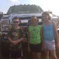 Kids posed in front of a truck.